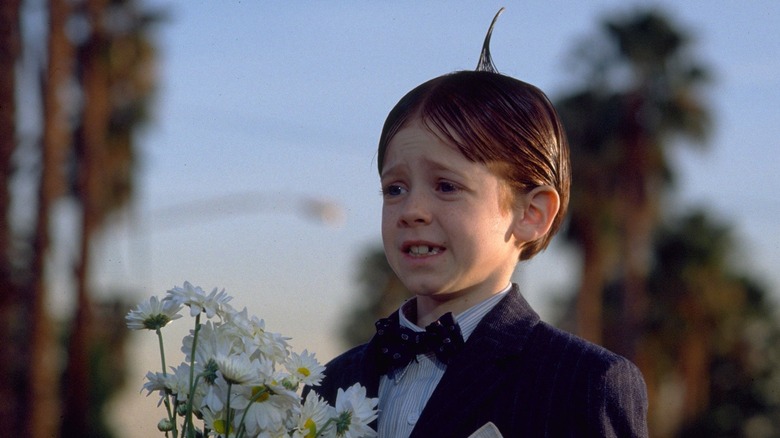 Alfalfa, timid, in a suit, holding a bouquet of flowers in The Little Rascals