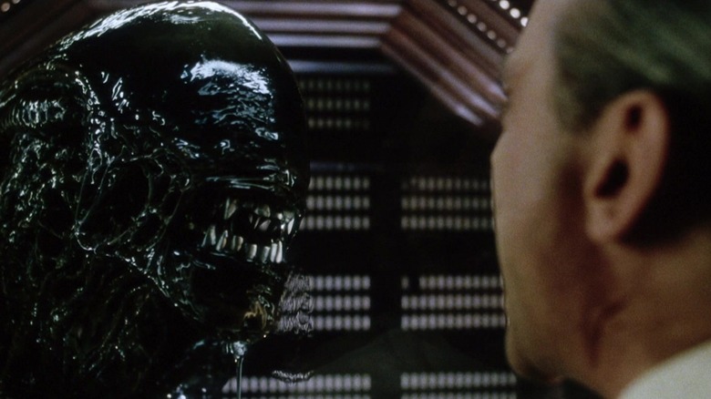 Scientist looking through glass a Xenomorph in Alien: Resurrection