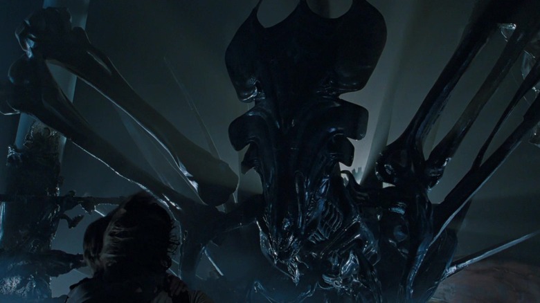 The Queen alien towering over someone in Aliens