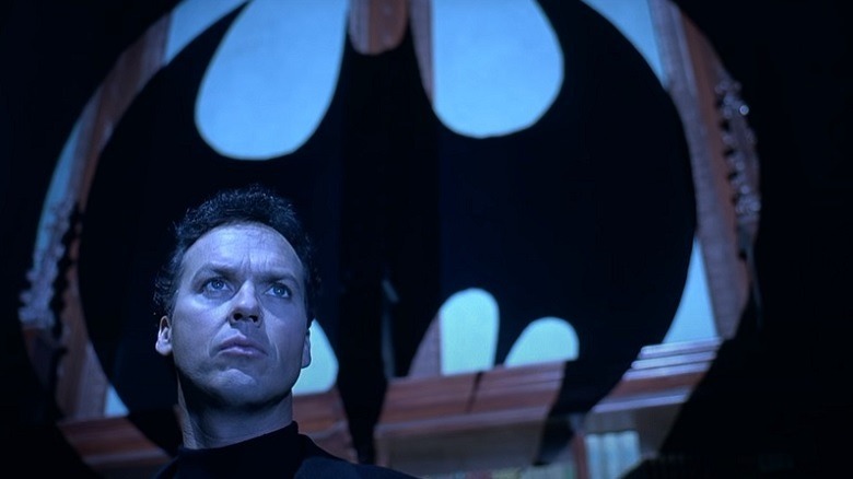 Michael Keaton standing in front of the bat signal