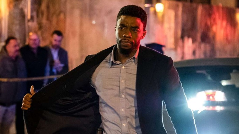 Chadwick Boseman as Andre Davis flashing his badge in 21 Bridges