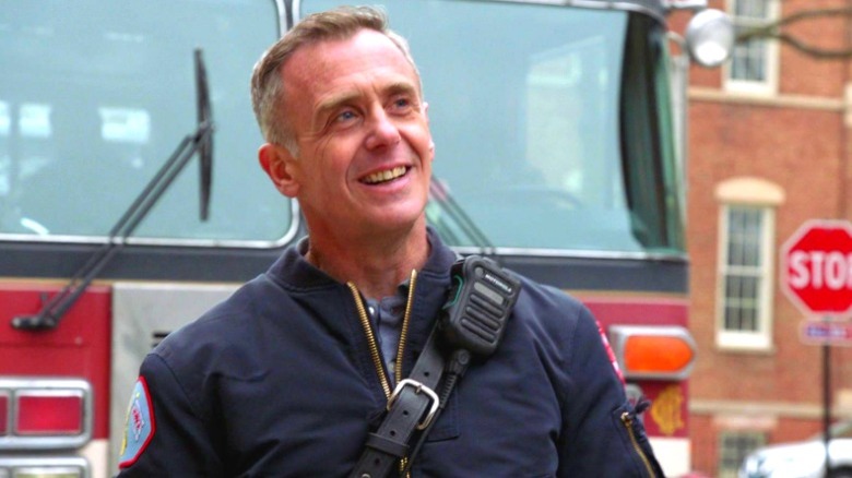 Chicago Fire's Herrmann smiles in front of a fire truck