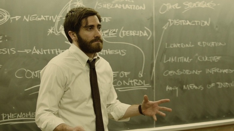 Jake Gyllenhaal as professor Adam Bell in front of chalkboard in Enemy