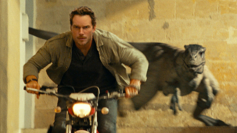 Chris Pratt and a assassin raptor in "Jurassic World Dominion"