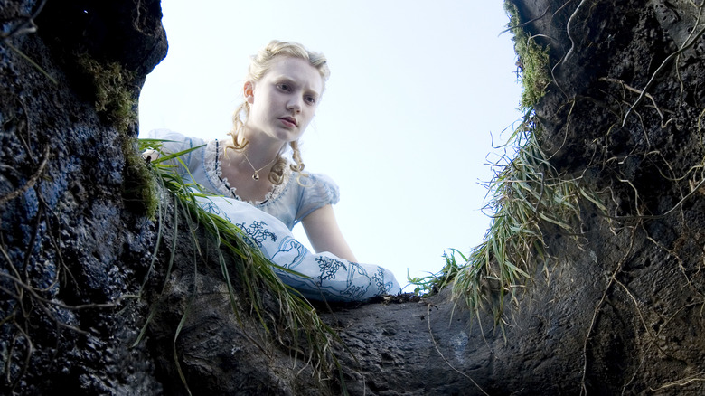 Alice (Mia Wasikowska) looks down the rabbit hole in Alice in Wonderland