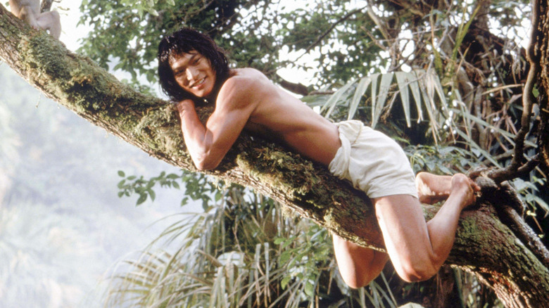 Mowgli (Jason Scott Lee) lying on tree branch in Rudyard Kipling's The Jungle Book