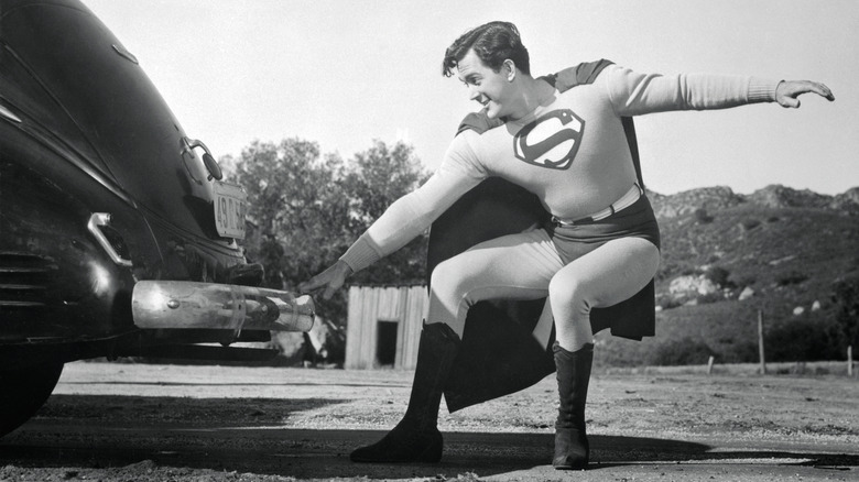 Kirk Alyn as Superman pulling a car's bumper in Superman