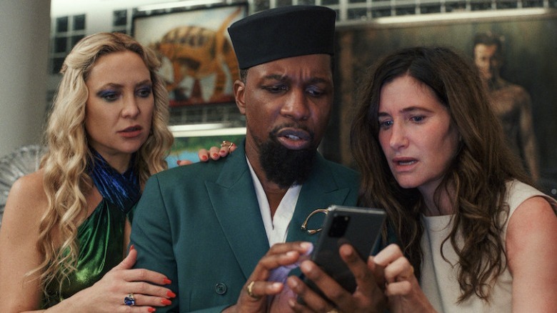 Kate Hudson, Leslie Odom Jr., Kathryn Hahn looking at phone