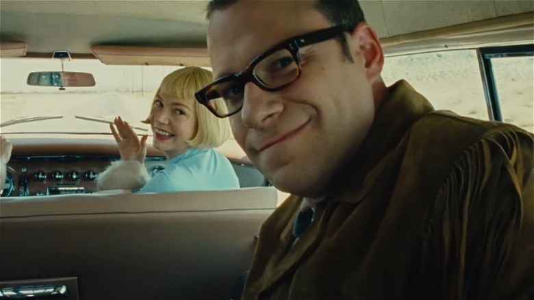 The Fabelmans' Michelle Williams and Seth Rogen looking back at camera in car