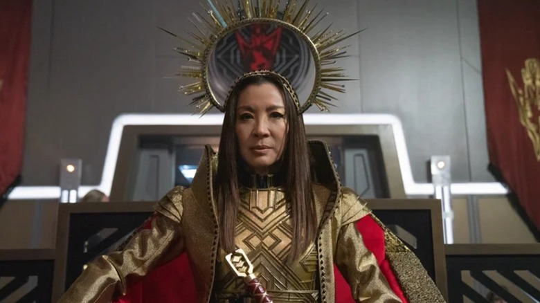 Michelle Yeoh's Philippa Georgiou sits on a throne wearing an elaborate spiked golden headdress in Star Trek: Discovery