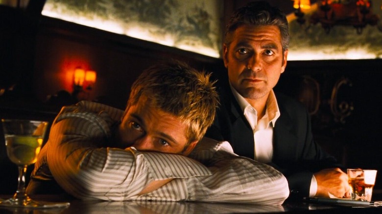 Rusty leaning on a bar and Danny looking forward in Ocean's Eleven