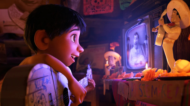 Miguel holds his guitar while watching Ernesto de la Cruz on television in Coco (2017)