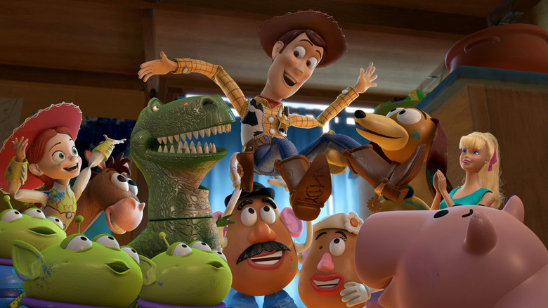 Woody's gang holds him up high in Toy Story 3