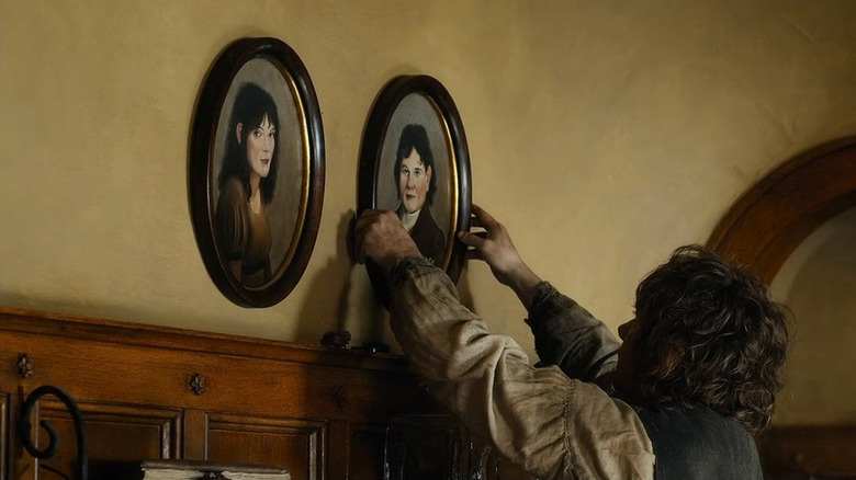 Bilbo hanging pictures of his parents over the fireplace in The Hobbit: The Battle of the Five Armies