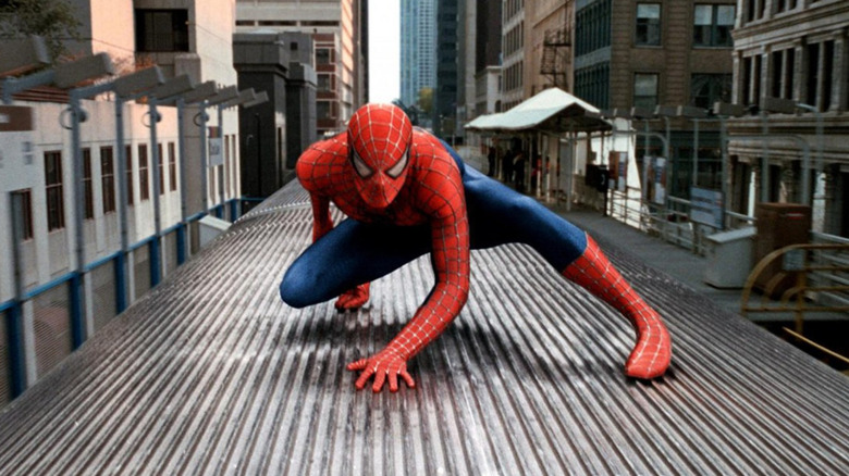 Spider-Man crouches while fighting on top of a train in Spider-Man 2