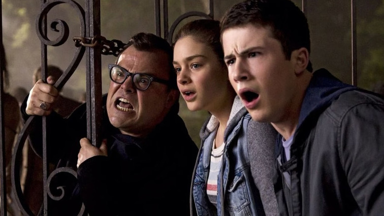 Jack Black as R.L. Stine looking angry next to Hannah (Odeya Rush) and Zach (Dylan Minnette) in Goosebumps