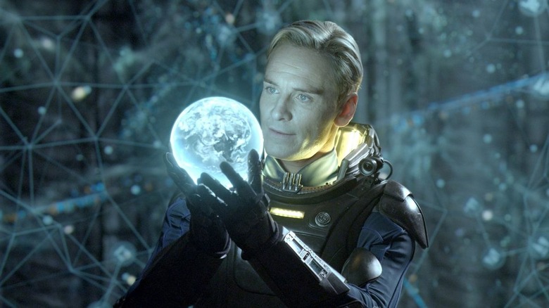 Michael Fassbender as David holding glowing sphere