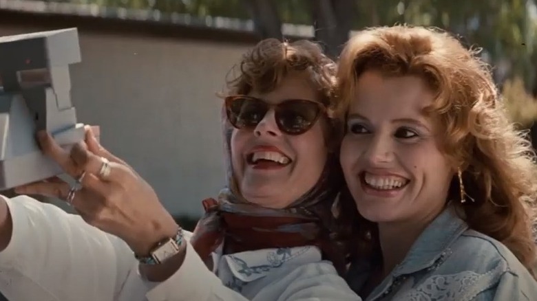 Susan Sarandon and Geena Davis sitting on car