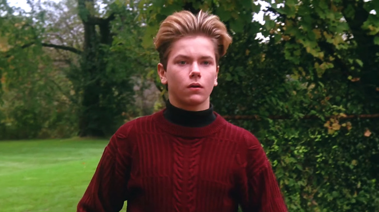 River Phoenix as Jimmy Reardon wearing red sweater