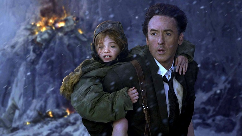 A man holds a little girl on a snowy mountain