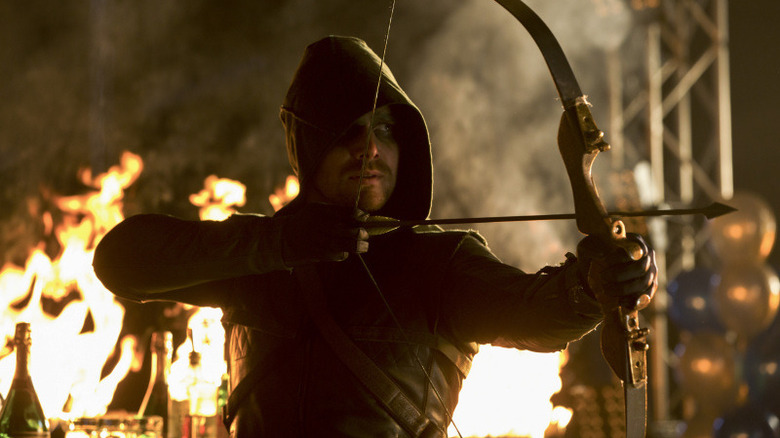 Arrow's Green Arrow aims in a fiery building