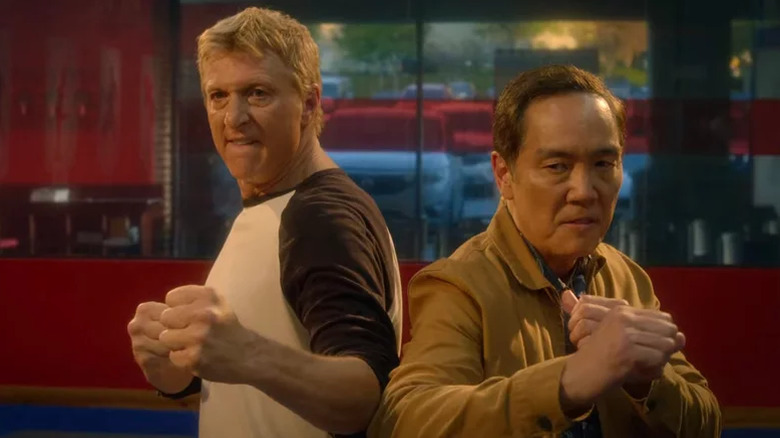 Johnny and Chozen raising their fists in a fighting stance in Cobra Kai