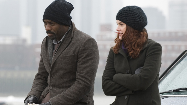 John Luther and Alice Morgan cold sitting on a car