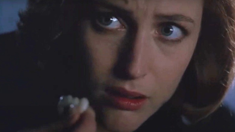 Scully holding fake teeth