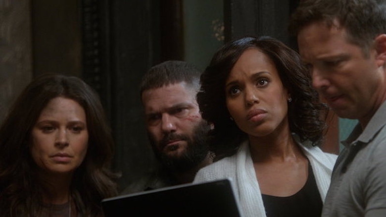 Olivia Pope holding tablet and looking up surrounded by coworkers on Scandal