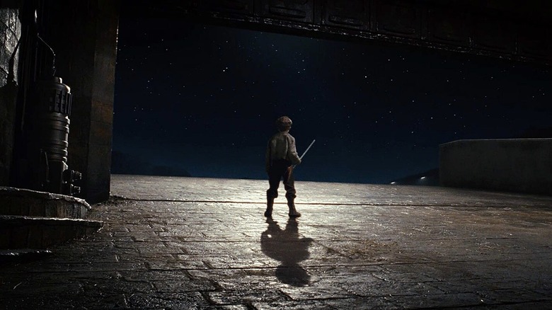 Broom boy looking up at the sky at the end of Star Wars: The Last Jedi