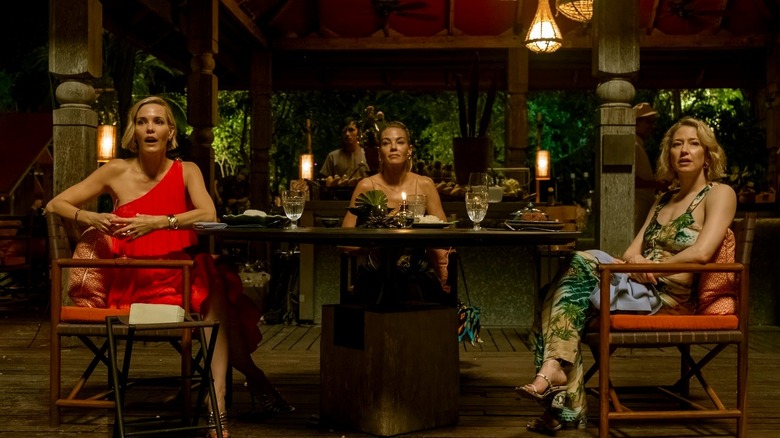 Kate Lyeklin and Lori sit on a dining table in the white lotus