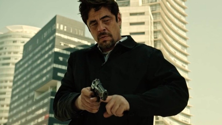 Alejandro Gillick pointing a gun at the floor in Sicario: Day of the Soldado