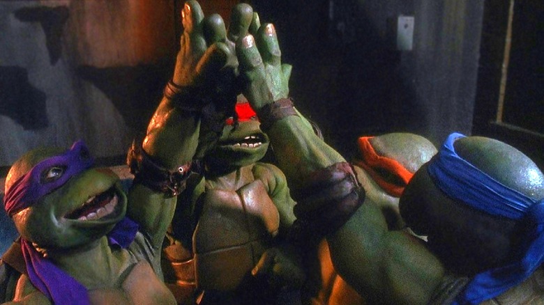 The Ninja Turtles share a group high five