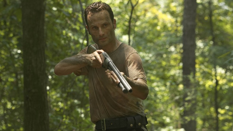 Clean-shaven Rick Grimes holds a gun