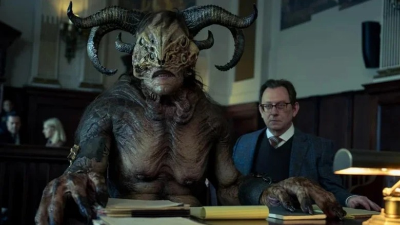 Fedor Steel's Henry, a massive demon, sits beside Michael Emerson's Leland in court in Evil