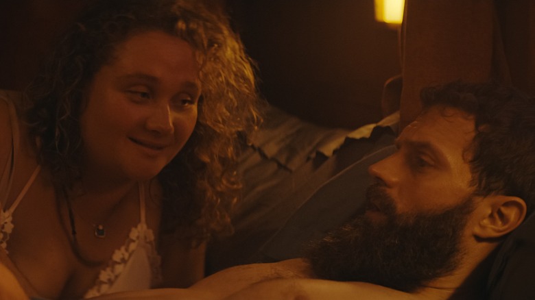 Danielle Macdonald as Helen Chambers and Jamie Dornan as Elliot lay in bed in The Tourist