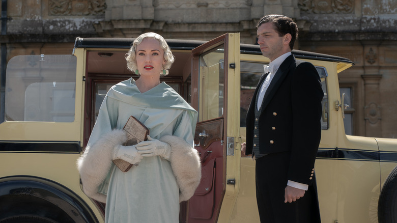 Laura Haddock and Michael Fox standing outside Downton in Downton Abbey: A New Era