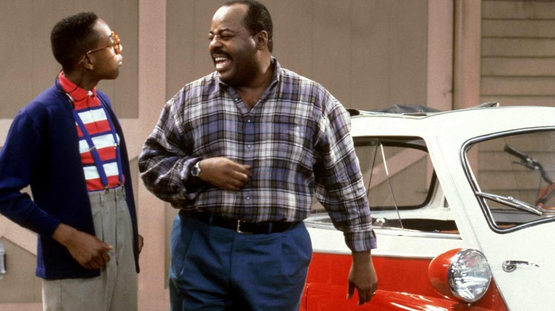 Carl Winslow olha com raiva para Steve Urkel, em frente ao seu carro