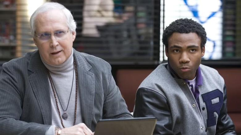 Chevy Chase and Donald Glover as Pierce Hawthorn and Troy Barnes, sitting next to each other in the study room in Community