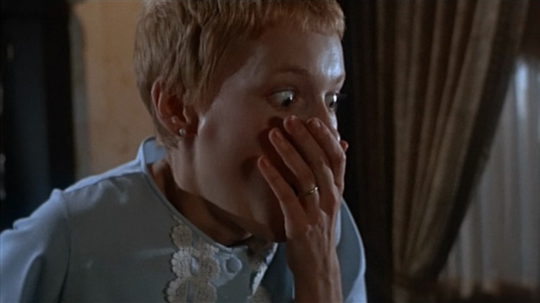 Rosemary from Rosemary's Baby with wide eyes and hand over mouth