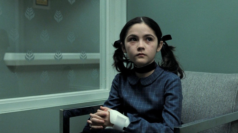 Esther the evil orphan sitting with a cast on her arm in the movie Orphan