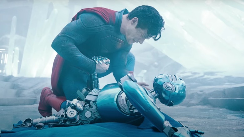 Superman mourning over a dying robot