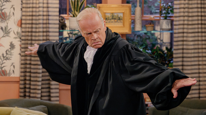 Frasier poses dramatically in a living room wearing black robes as part of a murder mystery party