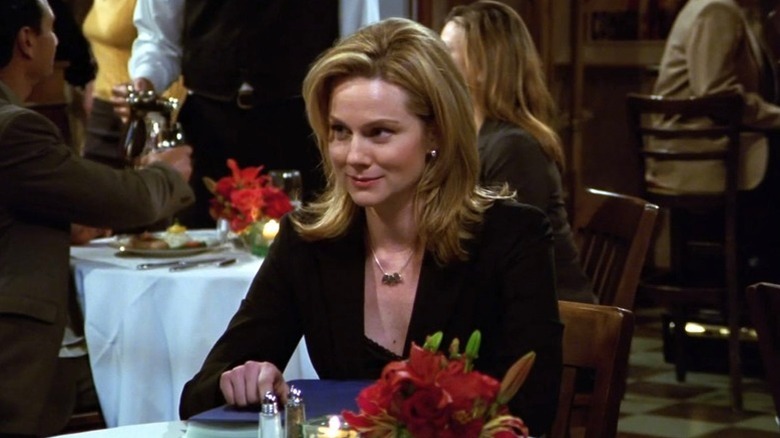 Laura Linney as Charlotte Connor seated at a table in a restaurant in Frasier