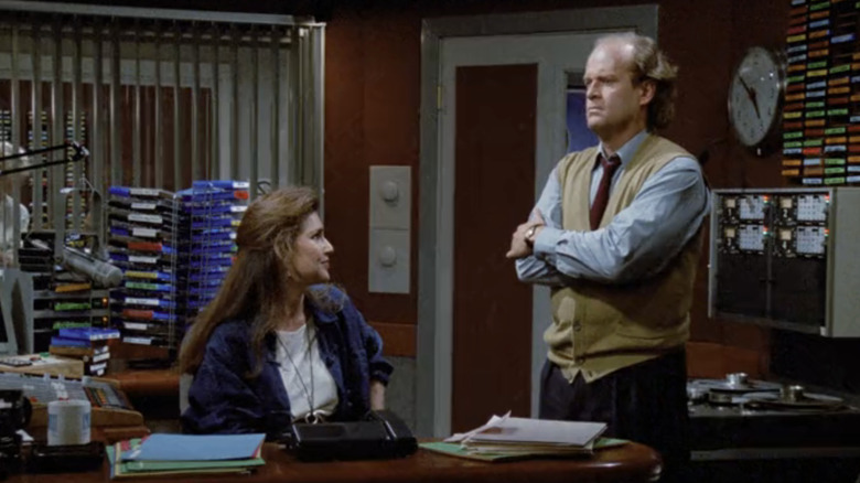 Frasier Crane, de Kelsey Grammer, e Roz Doyle, de Peri Gilpin, estão na cabine do produtor em um estúdio de rádio em Frasier