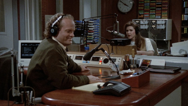 Frasier Crane, de Kelsey Grammer, e Roz Doyle, de Peri Gilpin, sentam-se em seus assentos em um estúdio de rádio em Frasier