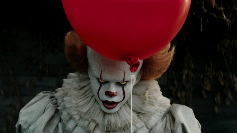 Pennywise holding a red balloon in IT (2017)