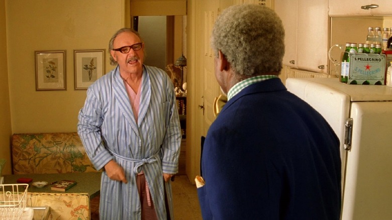 Royal Tenenbaum (Gene Hackman) stands in a robe and yells angrily at Henry Sherman (Danny Glover)