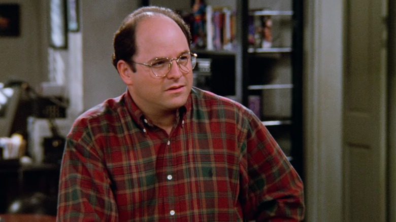 Jason Alexander's George Costanza wearing plaid, standing in Jerry's apartment in Seinfeld