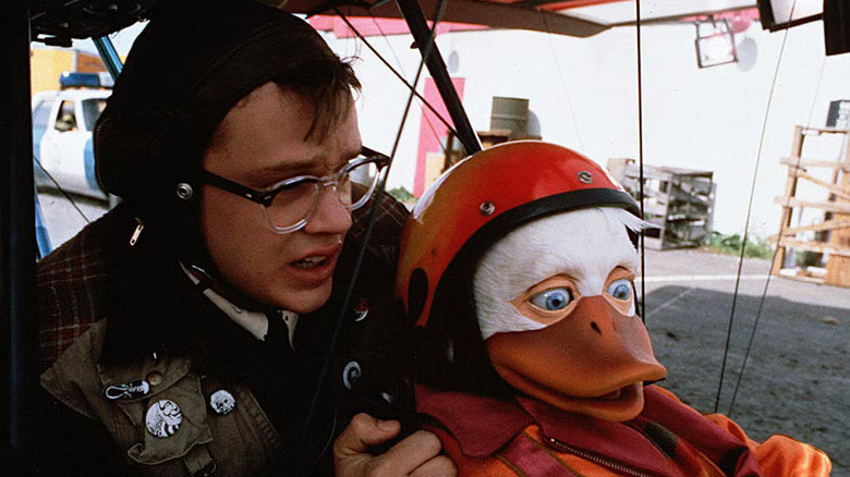 Tim Robbins as Phil Blumburtt and Howard the Duck look nervous in a cockpit in Howard the Duck